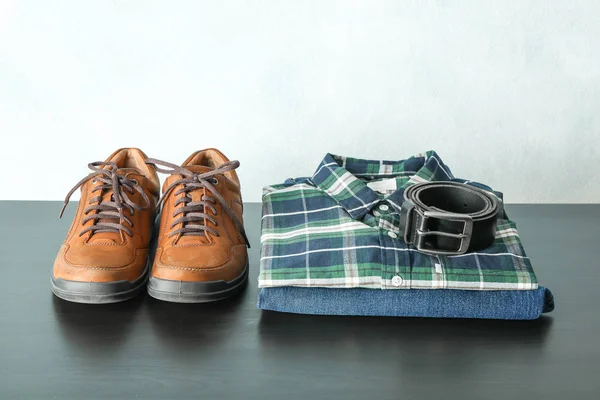 Stapel Hemd Jeans Und Gürtel Mit Schuhen Auf Dem Tisch — Stockfoto