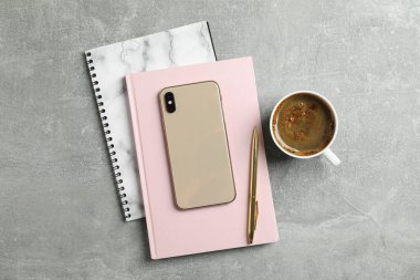 Kahve copybooks, telefon ve gri arka plan üzerinde kalem, 