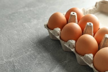 Tavuk yumurtası gri arka plan, metin için yer üzerine karton kutuda