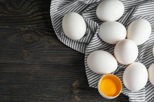 Mutfak havlusu ahşap arka plan, te alan üzerinde tavuk yumurta — Stok fotoğraf