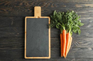 Kesme tahtası ve ahşap masa üzerinde olgunlaşmış havuç