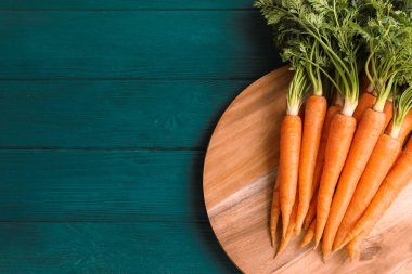 Ahşap masa üzerinde olgunlaşmış havuç ile kesme tahtası