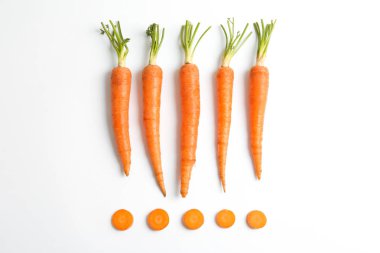 Beyaz arka plan üzerinde olgunlaşmış taze havuç ile düz yatıyordu kompozisyon