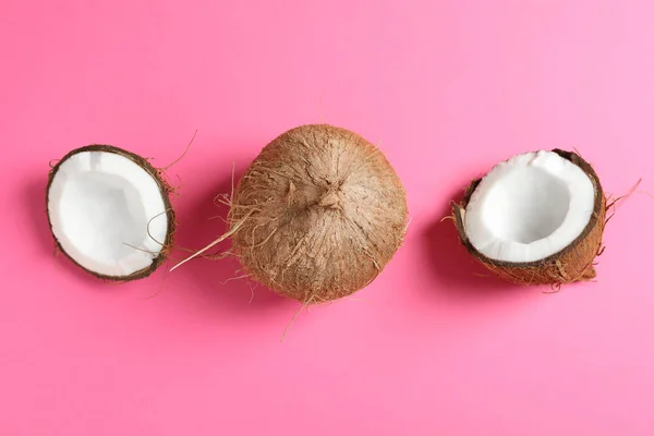 Два кокоса, один из которых расщепляется на цветном фоне, пространство для te — стоковое фото
