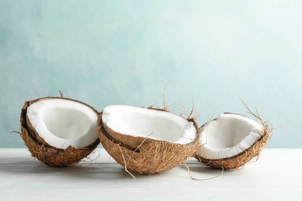 Cocos sobre mesa de madeira branca contra fundo cinza — Fotografia de Stock