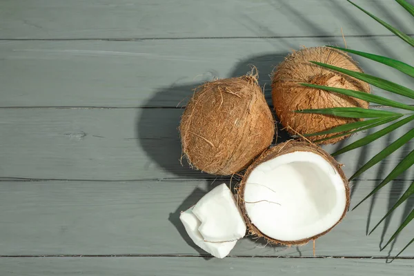 Cocos com ramo de palma na mesa de madeira, espaço para texto — Fotografia de Stock