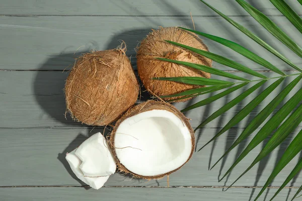 Cocos con rama de palma sobre mesa de madera, espacio para texto — Foto de Stock