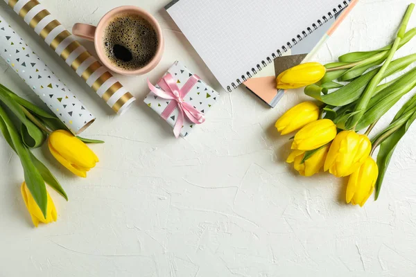 Beautiful tulips, copybooks, present and cup of coffee on white — Stock Photo, Image