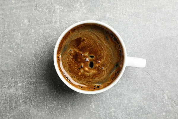 Kopp nybryggt kaffe på grå bord, ovanifrån — Stockfoto