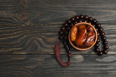 Ahşap arka planda tarihler ve dua boncuklar ile ahşap kase, SP