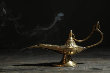 Koyu arka plana karşı ahşap masada Magic Aladdin lamba