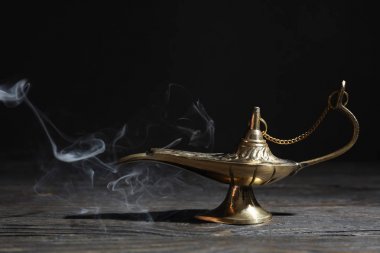 Koyu arka plana karşı ahşap masada Magic Aladdin lamba