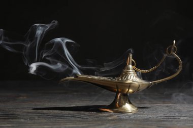 Koyu arka plana karşı ahşap masada Magic Aladdin lamba