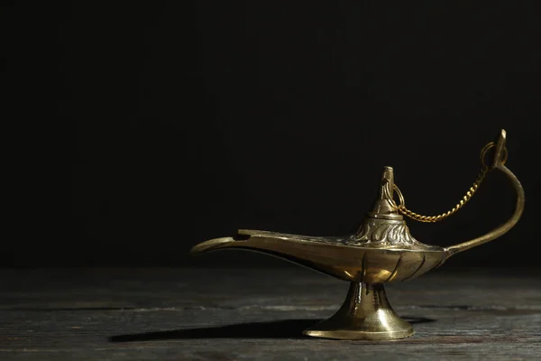 Magic Aladdin Lamp on wooden table against dark background
