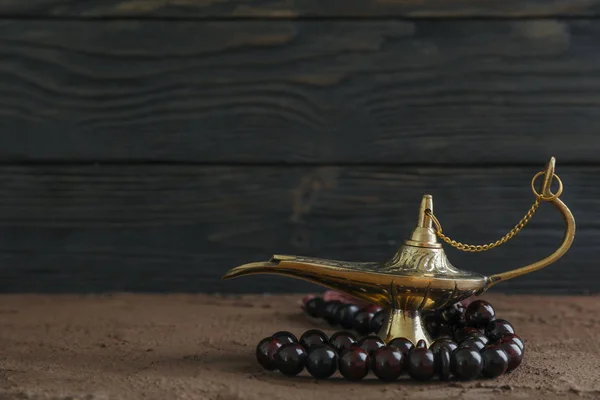 Mágikus Aladdin lámpa imádság gyöngyök a barna asztal ellen jaj — Stock Fotó