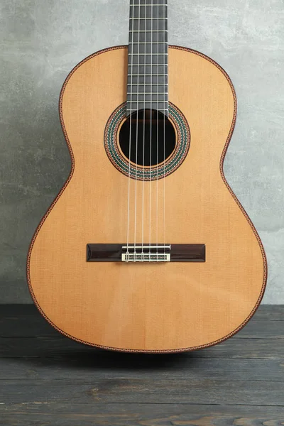 Piękna sześciostrunowa klasyczna gitara na drewnianym stole przeciwko gr — Zdjęcie stockowe