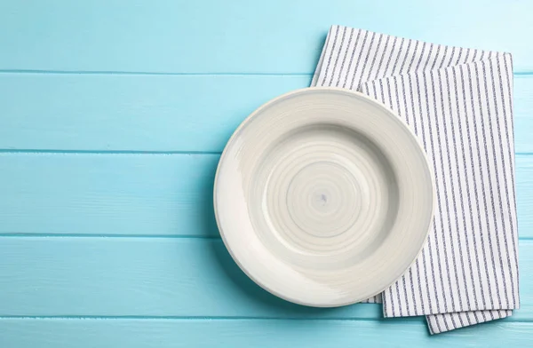 Küchentuch mit Teller auf Holzhintergrund, Draufsicht — Stockfoto