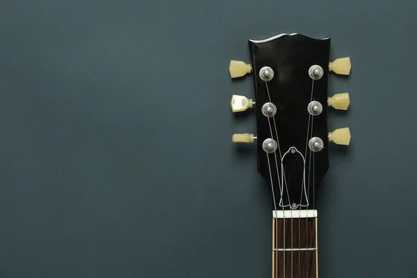 Electric guitar neck on dark background, space for text