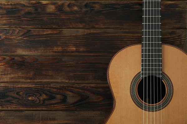 Piękna sześciostrunowa klasyczna gitara na drewnianym tle, spac — Zdjęcie stockowe