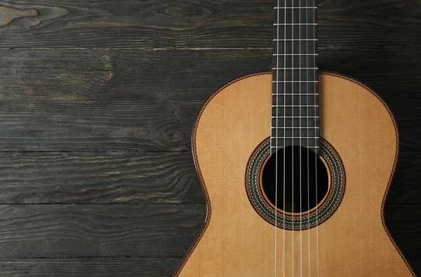 Piękna sześciostrunowa klasyczna gitara na drewnianym tle, spac — Zdjęcie stockowe