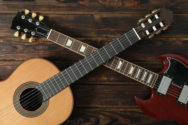 Elektryczna i klasyczna gitara na drewnianym tle, widok z góry — Zdjęcie stockowe