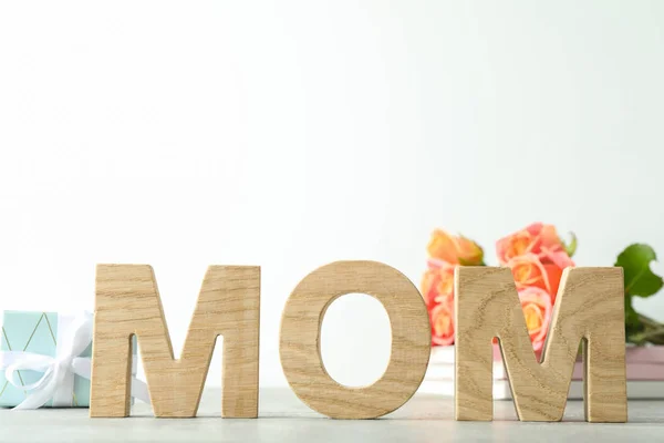 Aufschrift Mama, schöne rosa Rosen und Geschenk auf grauem Tisch aga — Stockfoto