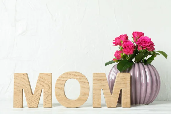 Inschrift Mama und Vase mit rosa Rosen auf weißem Tisch, Raum f — Stockfoto