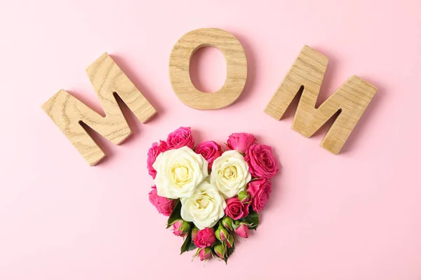 Inskripsi Mom dengan mawar dalam bentuk hati pada latar belakang warna — Stok Foto