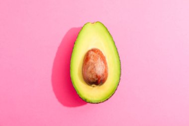 Rip pembe arka plan üzerinde avokado kesilmiş, metin için alan