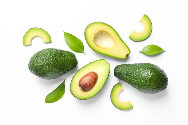 Platte lay compositie met rijpe avocado's en bladeren op witte rug — Stockfoto