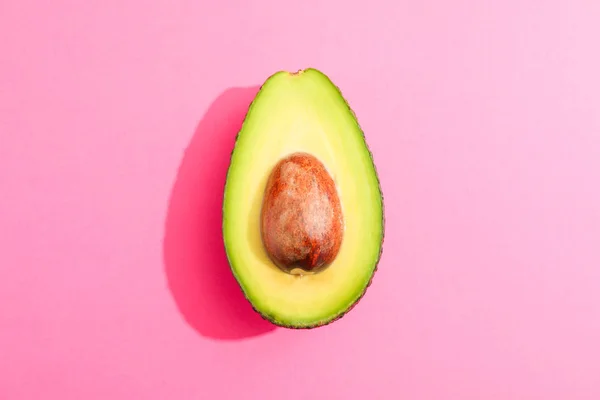 RIP cut avocado op roze achtergrond, ruimte voor tekst — Stockfoto