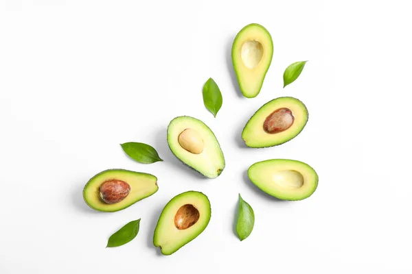 Platte lay compositie met rijpe avocado's en bladeren op witte rug — Stockfoto