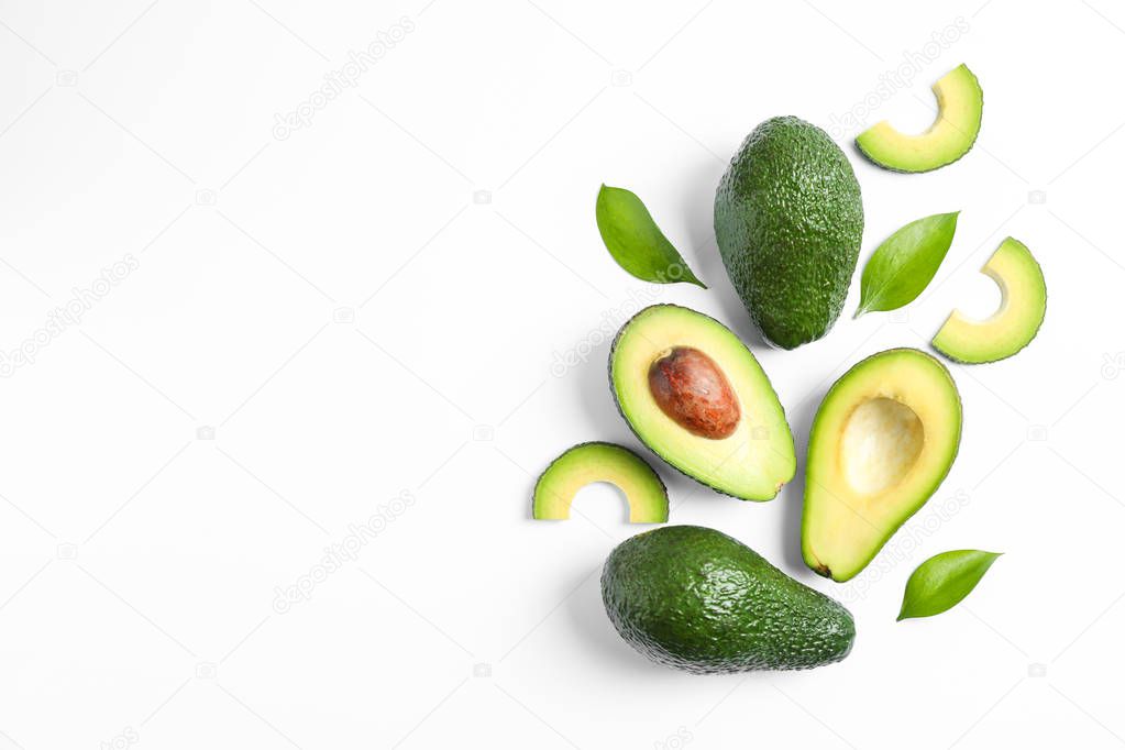 Flat lay composition with ripe avocados and leaves on white back