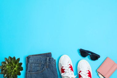 Düz lay kompozisyon: kadın giysi ve aksesuarları, mavi arka plan üzerinde lezzetli bitki. Yaz arka planı, yakın çekim