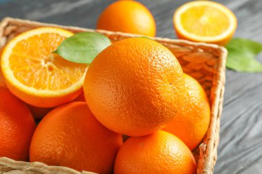 Tahta masada olgun portakallarla dolu bir sepet, yakın plan.