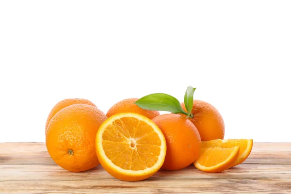 Reife Orangen mit Blättern auf Holztisch isoliert auf weißem Rücken — Stockfoto