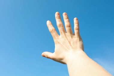 Kadın el ile güzel mavi gökyüzü arka plan. Harika gökyüzü