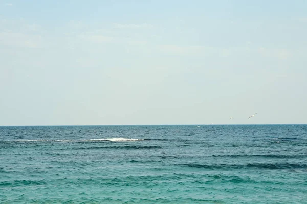 Agua de mar azul con pequeñas olas contra el cielo. Espacio para texto — Foto de Stock