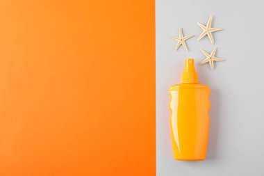 Güneş kremi spreyi ve denizyıldızları ile kompozisyon iki ton geri