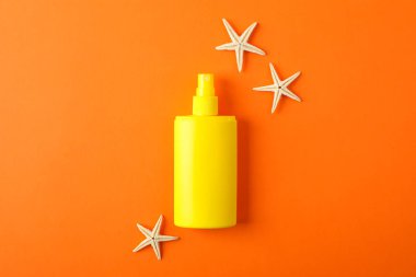 Renk backgro güneş kremi sprey ve denizyıldızları ile Kompozisyon