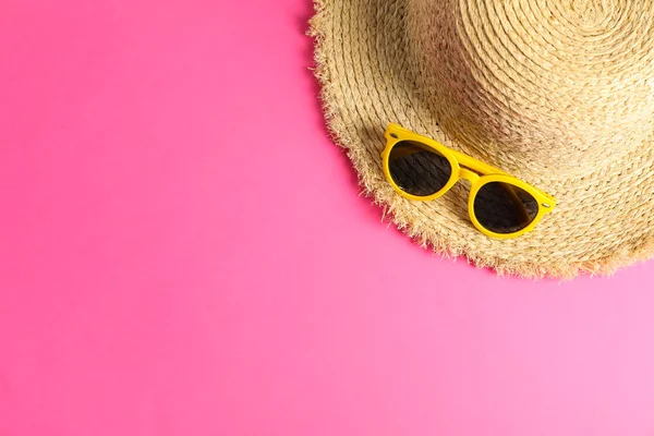 Sombrero de paja con gafas de sol sobre fondo de color, espacio para texto, t —  Fotos de Stock