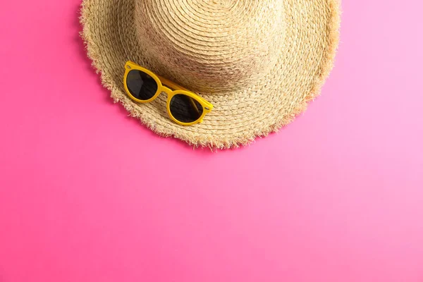 Sombrero de paja con gafas de sol sobre fondo de color, espacio para texto, t —  Fotos de Stock