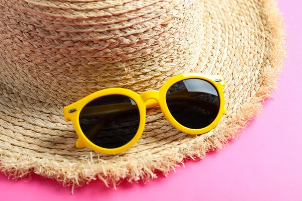 Sombrero de paja con gafas de sol sobre fondo de color, primer plano. Verano b —  Fotos de Stock