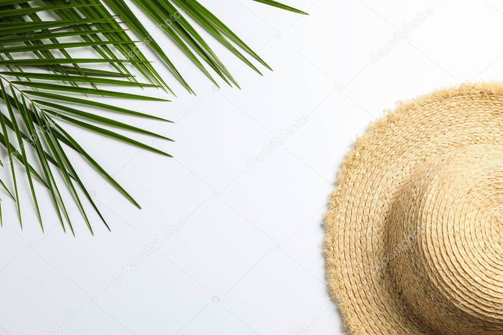 Composition with straw hat and palm leaves on white background. 