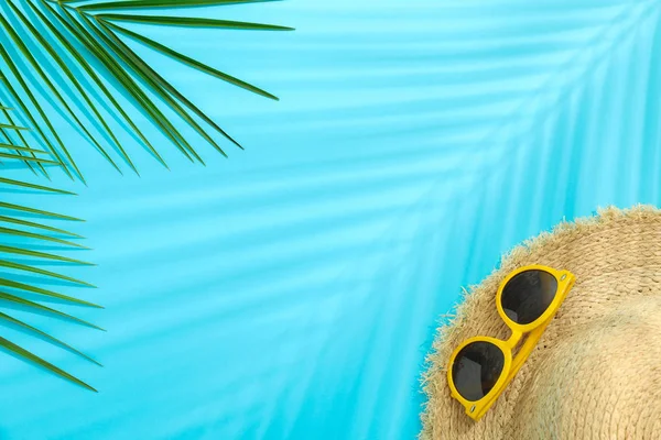 Folhas de palma, chapéu de palha e óculos de sol sobre fundo de cor, espaço — Fotografia de Stock
