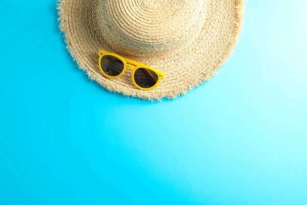 Sombrero de paja y gafas de sol sobre fondo de color, espacio para texto —  Fotos de Stock