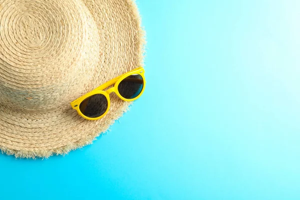 Sombrero de paja y gafas de sol sobre fondo de color, espacio para texto —  Fotos de Stock