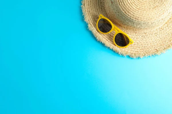 Sombrero de paja y gafas de sol sobre fondo de color, espacio para texto —  Fotos de Stock