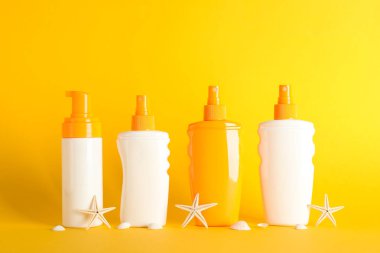 Renk arka planda denizyıldızları ile güneş kremi spreyler, alan için 