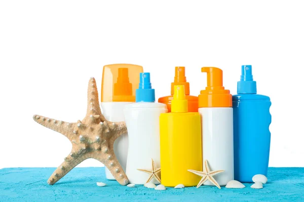 Diferentes sprays de protetor solar com estrelas-do-mar e conchas no colo — Fotografia de Stock